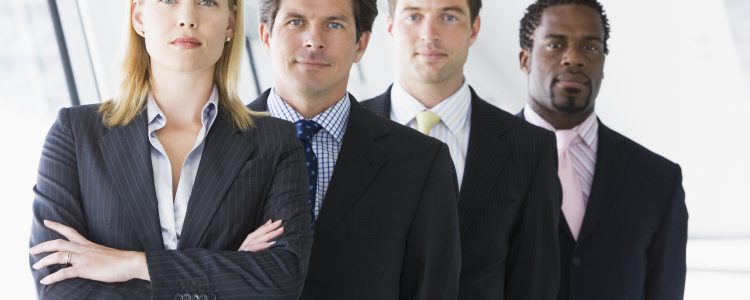Four businesspeople standing in corridor