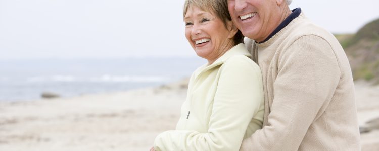 Couple at the beach embracing and smiling