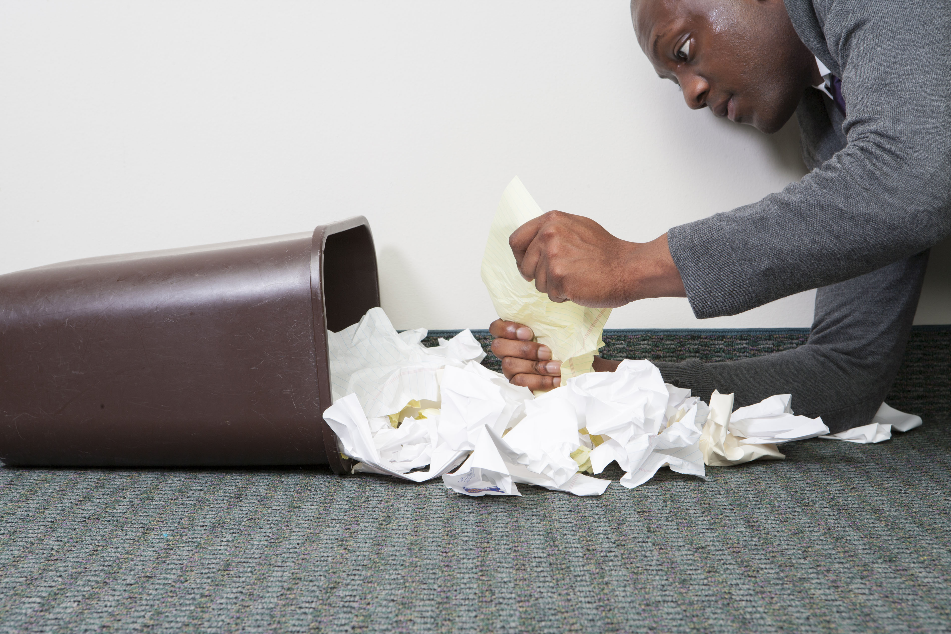 Business person looking in trash can