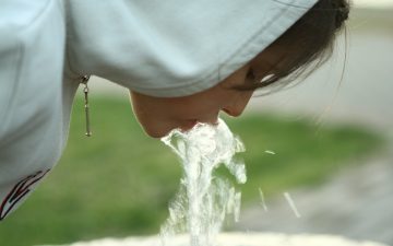 Little girl drinking water from fountain