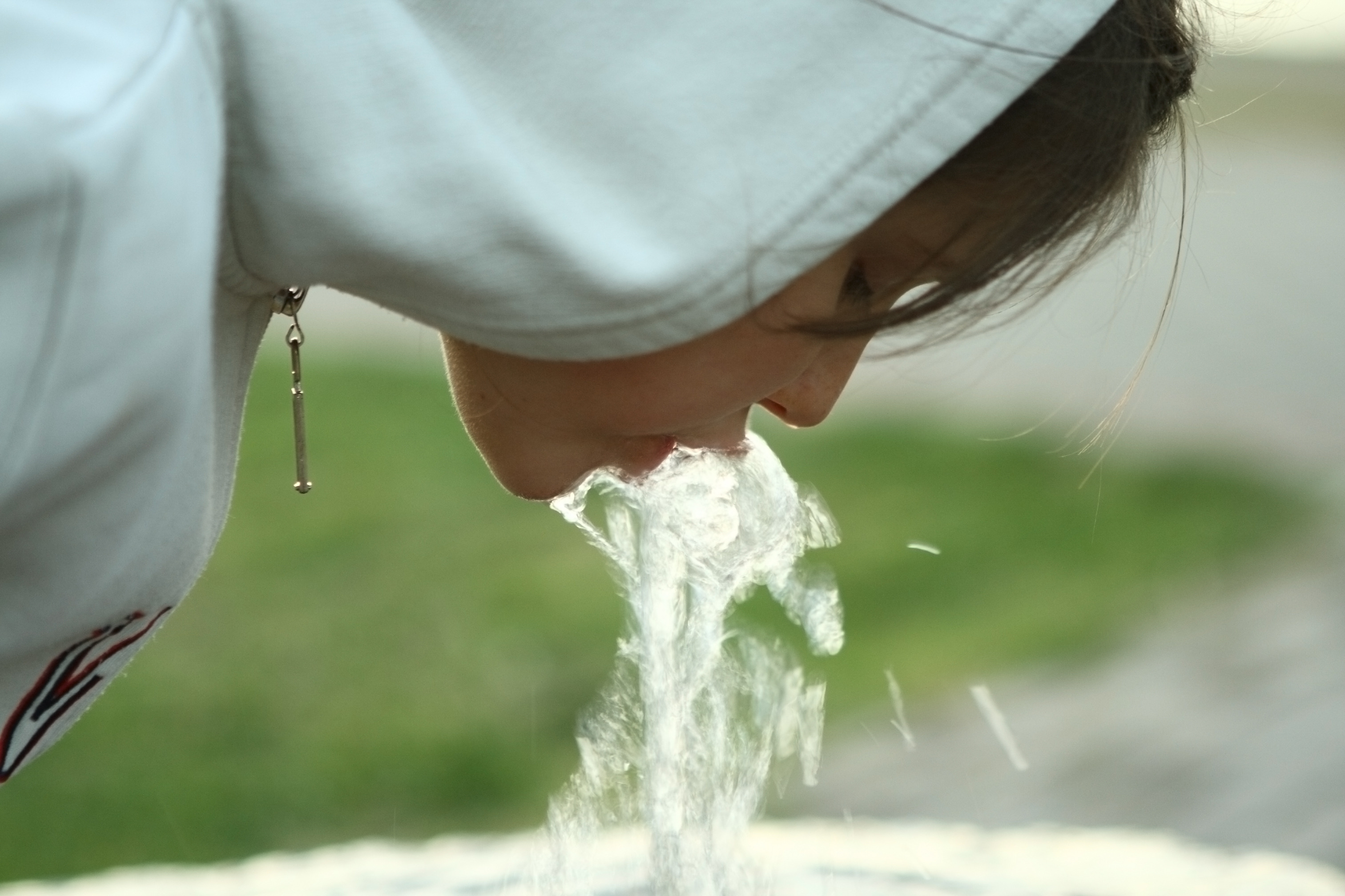 Little girl drinking water from fountain