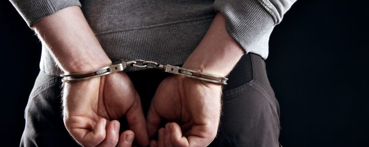 Outlaw’s Hands Locked in Handcuffs