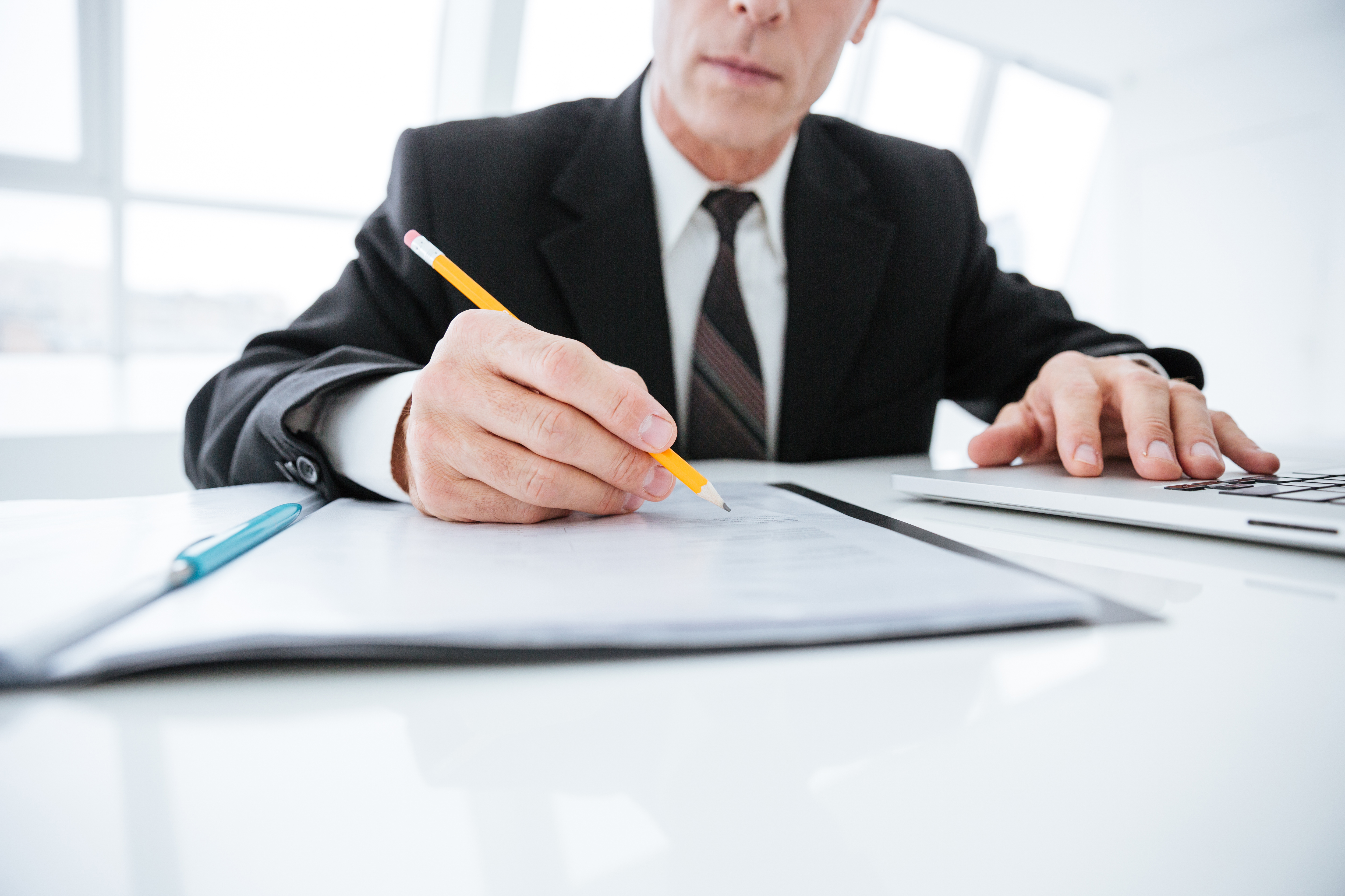 Cropped image of Elderly business man writing something